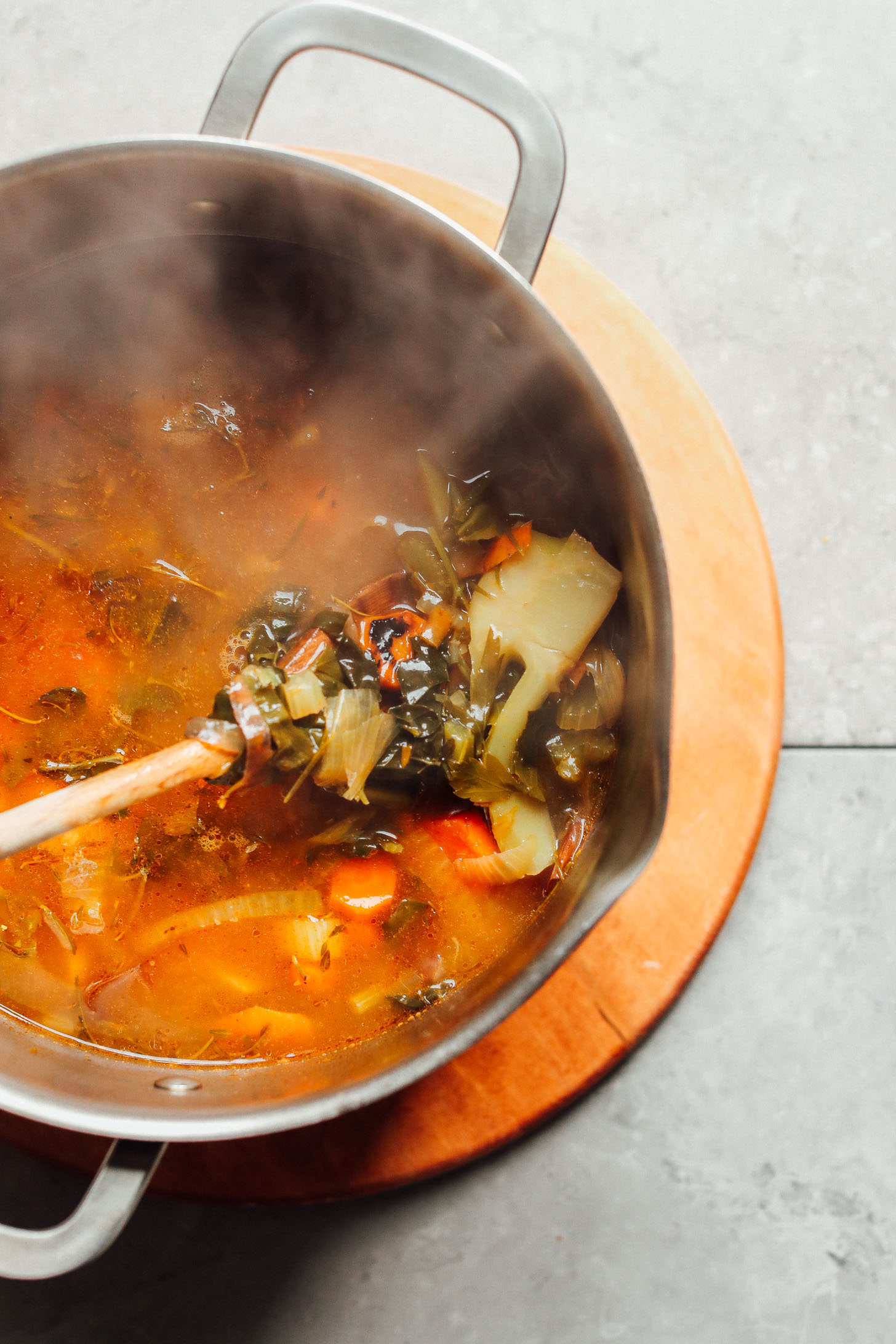Stirring a pot of simmering homemade vegetable broth