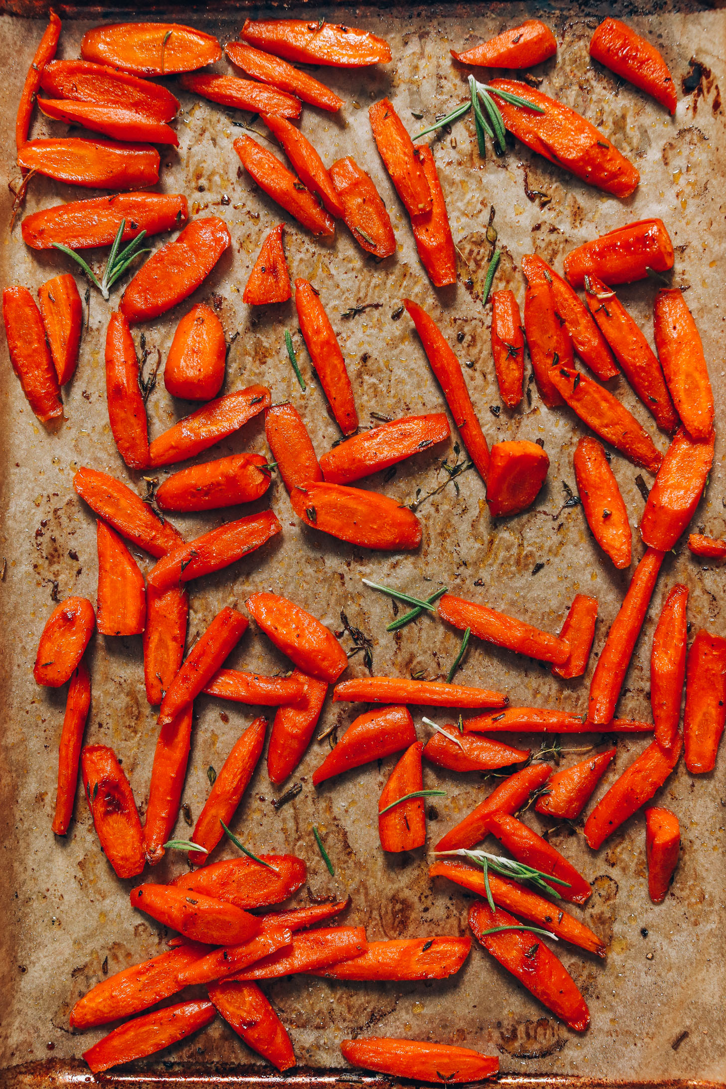 Baking sheet of roasted carrots with rosemary and thyme