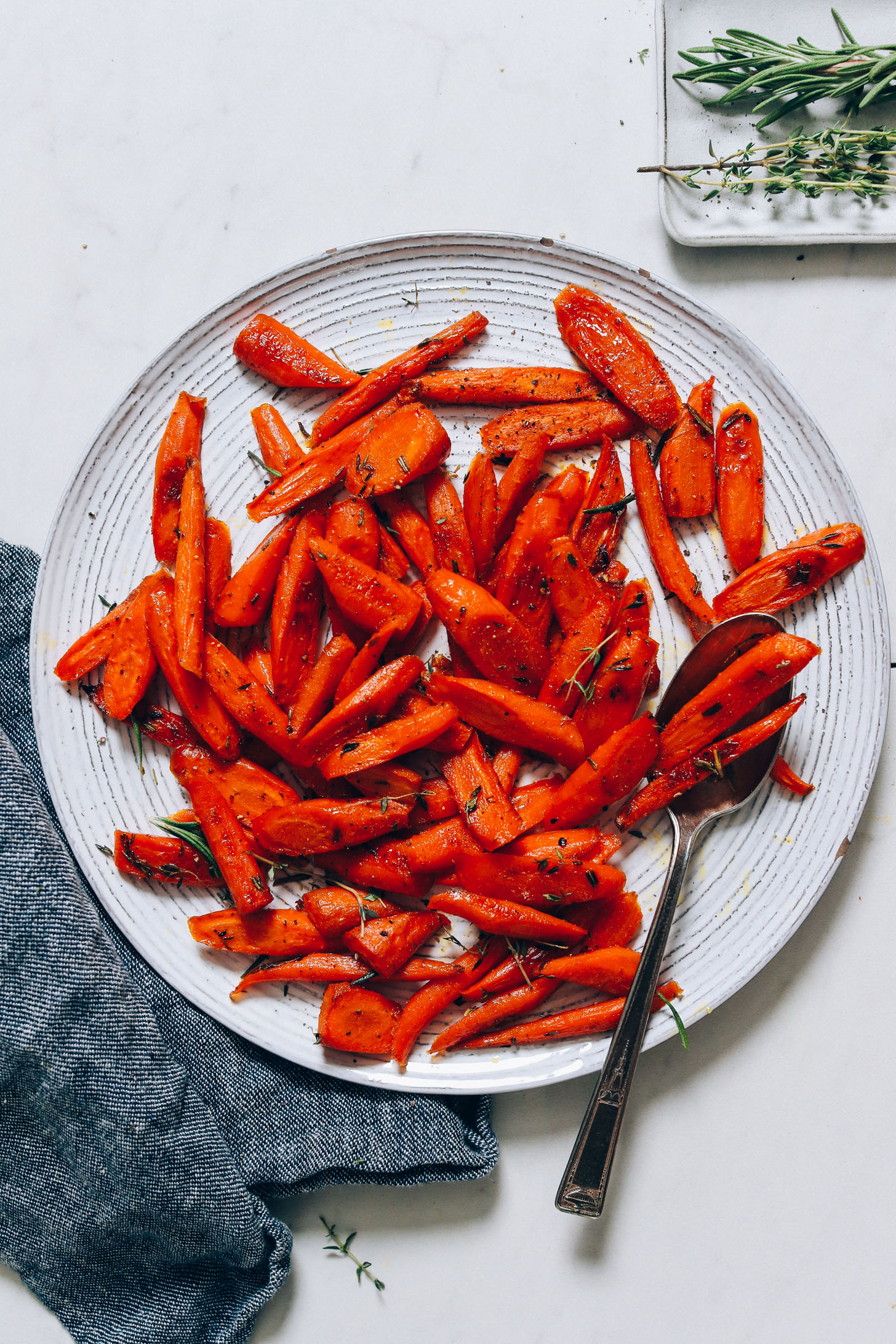 Platter of roasted carrots with fresh thyme and rosemary