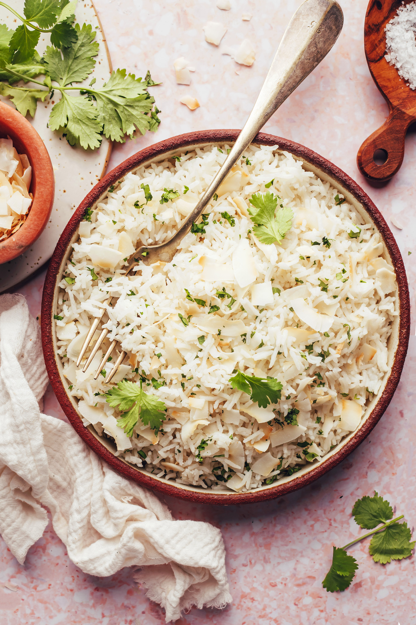 Bowl of coconut rice topped with coconut flakes and cilantro