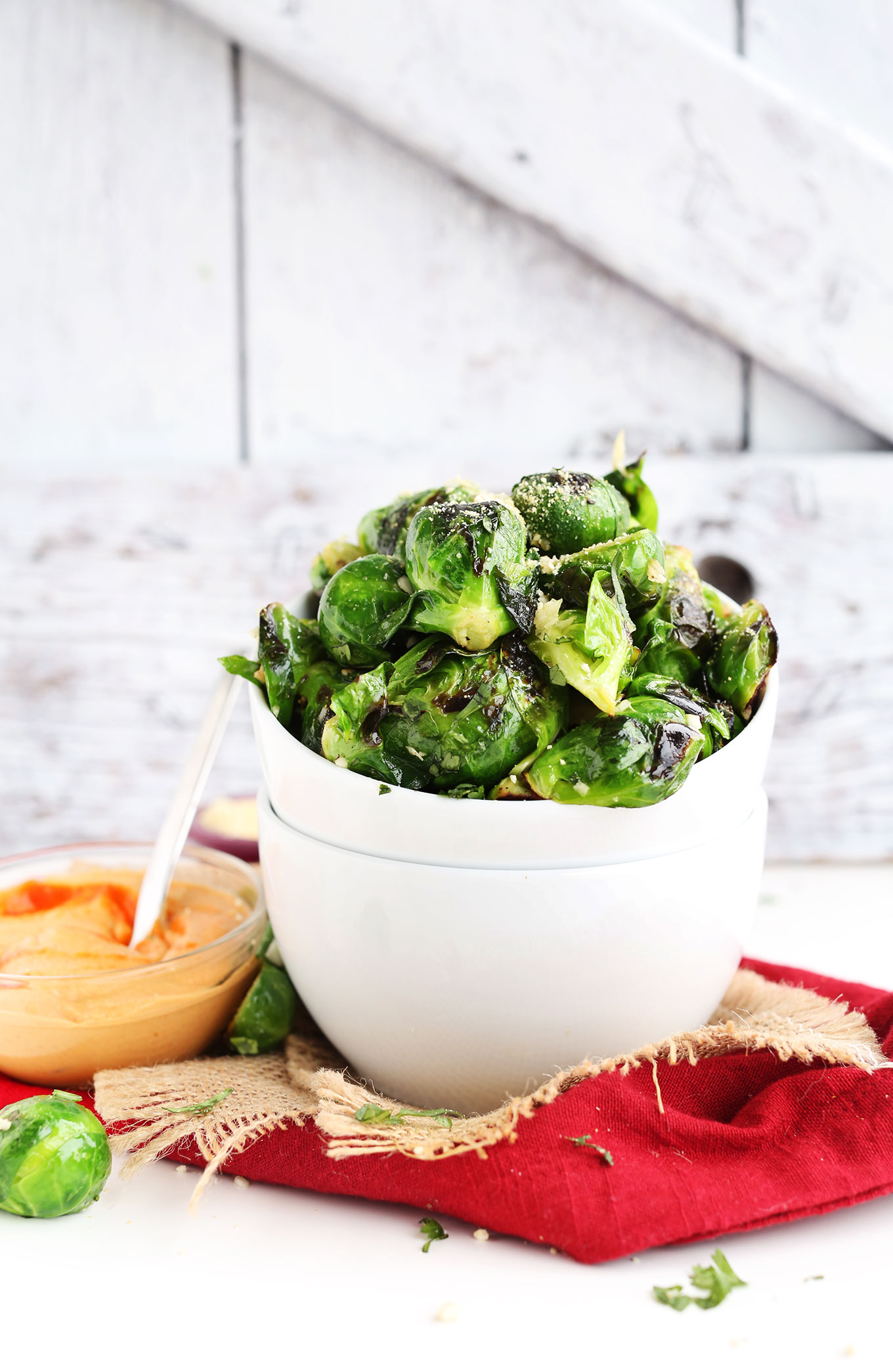 Bowl of Crispy Roasted Brussel Sprouts with a smaller bowl of spicy Sriracha Aioli