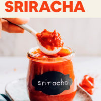 Spoonful of homemade sriracha above a jar